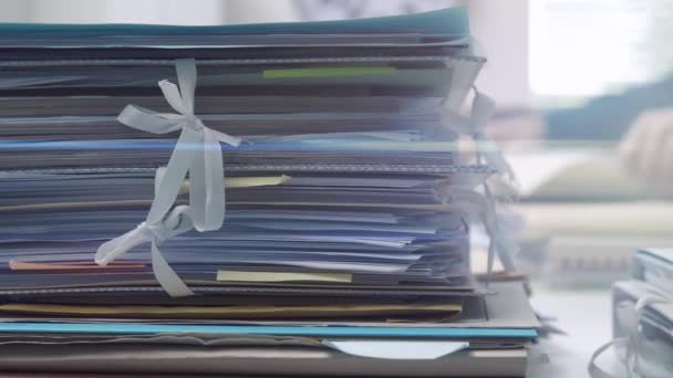 Empregado que trabalha no escritório e pilhas de papelada — Vídeo de Stock