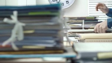 Ofis ve evrak yığınları içinde çalışan