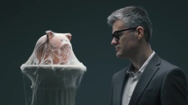 Örümcek ağları ile piggy banka üzerinde üfleme hayal kırıklığına sinirli işadamı: başarısız uzun vadeli yatırım fonları ve dondurulmuş banka hesap kavramı