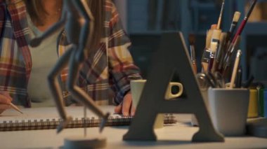 Genç sanat öğrencisi onun Studio bir eskiz defteri çizim ahşap bir manken, sanat ve yaratıcılık kavramı kullanarak insan figürü tasvir