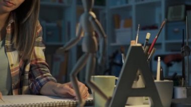 Genç sanat öğrencisi onun Studio bir eskiz defteri çizim ahşap bir manken, sanat ve yaratıcılık kavramı kullanarak insan figürü tasvir