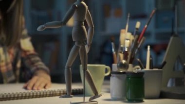 Genç sanat öğrencisi onun Studio bir eskiz defteri çizim ahşap bir manken, sanat ve yaratıcılık kavramı kullanarak insan figürü tasvir
