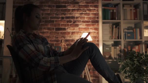 Menina Feliz Relaxar Uma Cadeira Casa Conectar Com Seu Smartphone — Vídeo de Stock