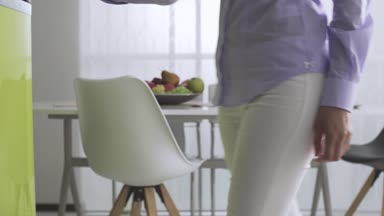 Genç gülümseyen kadın evde mutfakta, o buzdolabı açar ve lezzetli bir pasta alır