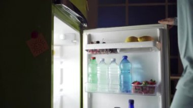 Buzdolabını açma ve lezzetli bir pasta bir gece yarısı snack, sağlıksız gıda ve beslenme çekici kadın kavramı başarısız