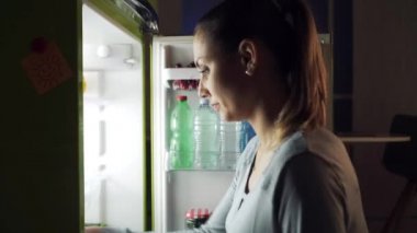 Açgözlü mutlu kadın lezzetli geç gece snack sahip: o küçük bir pasta alır ancak daha sonra büyük bir çikolatalı pasta seçer
