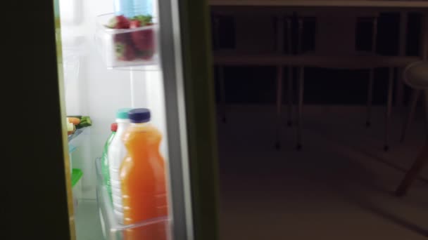 晚上在厨房里从冰箱里拿出一瓶牛奶的女人 — 图库视频影像