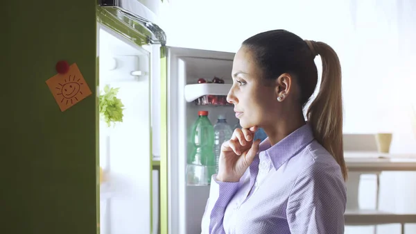 Giovane Donna Cucina Sta Guardando Frigorifero Pensando Con Mano Sul — Foto Stock