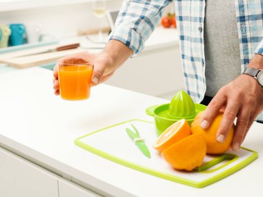 Erkek mutfak, sağlıklı gıda kavramı taze portakal suyu hazırlama