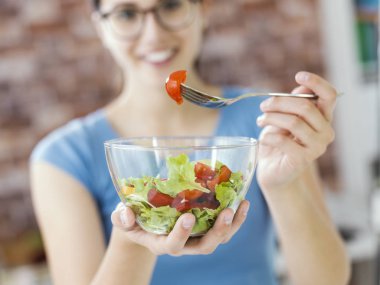 Taze salata bir kase, sağlıklı vegan gıda yemek ve kavram diyet mutlu genç kadın