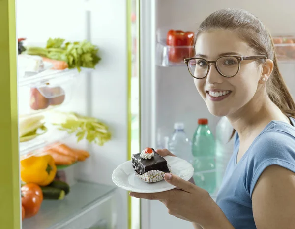 Счастливая Молодая Женщина Открывает Холодильник Ест Вкусный Шоколадный Десерт — стоковое фото