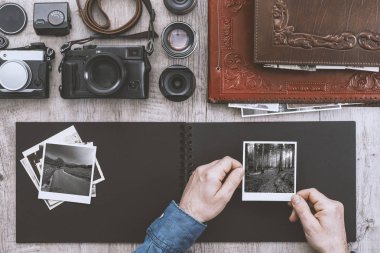 Fotoğrafik donanımlar, fotoğraf makinesi ve fotoğraf albümü, bir fotoğrafçı fotoğraf albümü ile anlık resimler doluyor