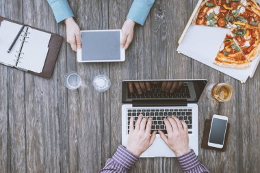 Ofis masasında çalışan iş adamları ve lezzetli bir pizzayla öğle yemeği arası veriyorlar.