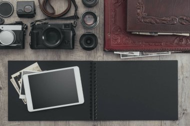 Fotoğrafik donanımlar, fotoğraf makinesi, dijital tablet ve boş fotoğraf albümü üstünde a okul sırası, düz yatıyordu
