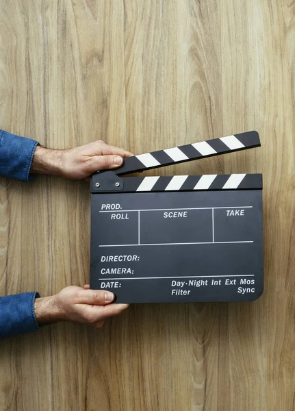 Film director holding a clapper board, filmmaking and cinema concept