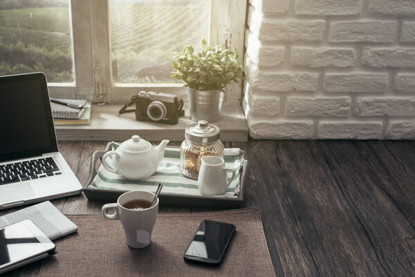 Healthy relaxing breakfast at home on a rustic wooden table with laptop and smartphone