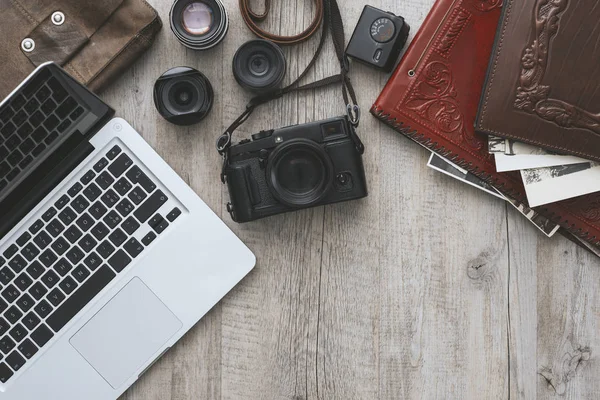 Hipster photography equipment with laptop on a vintage wooden desktop, flat lay
