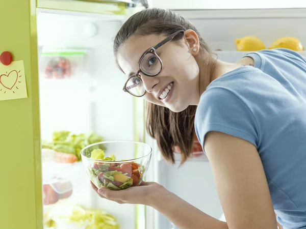 Жінка бере свіжий салат з холодильника — стокове фото