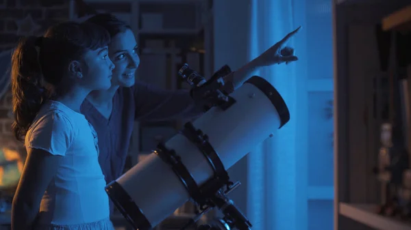 Cute sisters watching the stars with a telescope — Stock Photo, Image