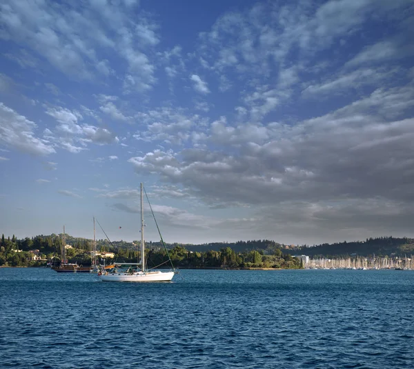 Segelbåt och turistiska hamn i bakgrunden — Stockfoto