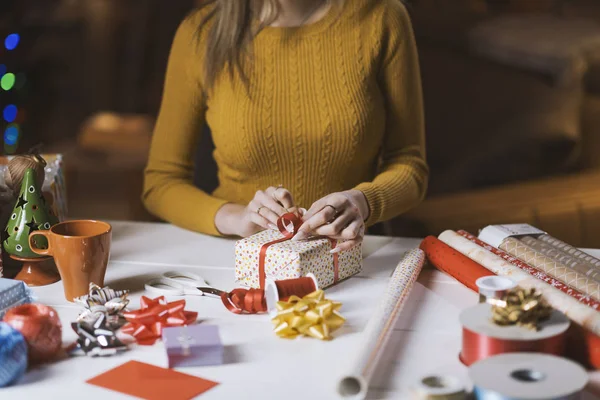 Femeia împachetează cadouri de Crăciun acasă — Fotografie, imagine de stoc