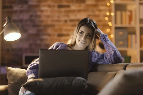 Mulher relaxante e assistindo filmes em seu laptop — Fotografia de Stock