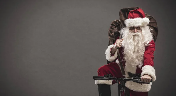 Weihnachtsmann fährt Fahrrad und trägt Geschenke — Stockfoto