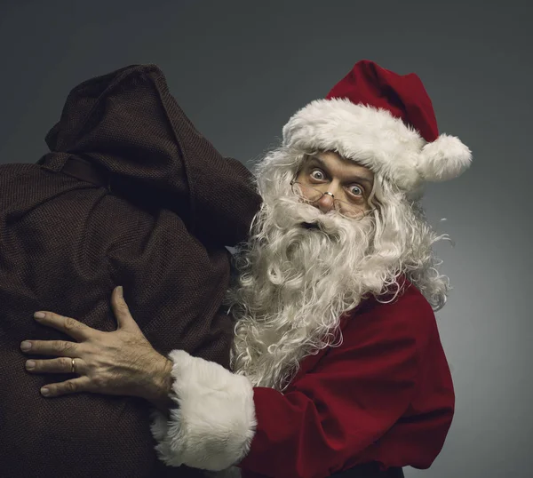 Papai Noel carregando um saco com presentes de Natal — Fotografia de Stock