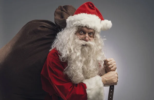 Papai Noel carregando um saco com presentes de Natal — Fotografia de Stock
