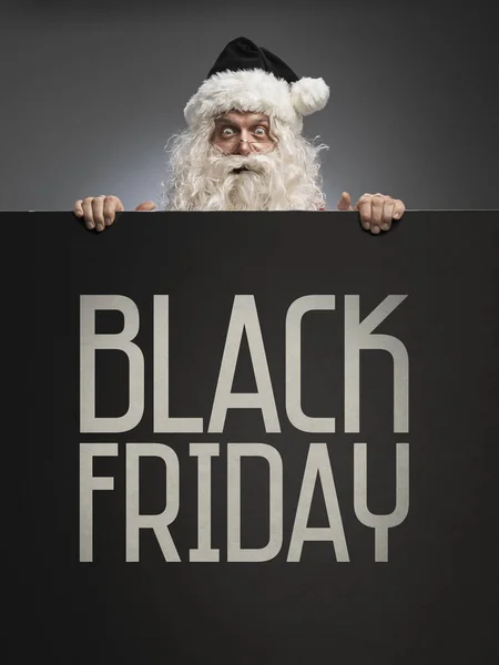 Santa Claus holding a Black Friday advertisement sign