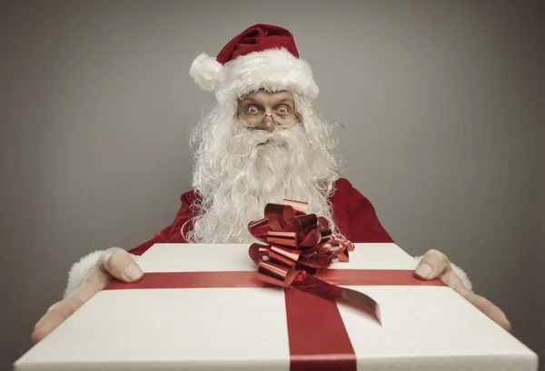 Santa Claus brengen een cadeau met rood lint — Stockfoto