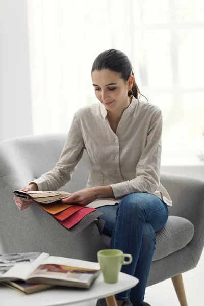 Mujer joven eligiendo la mejor tapicería para el sillón — Foto de Stock