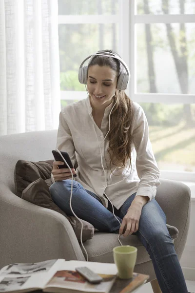 Evde müzik dinleyen bir kadın — Stok fotoğraf