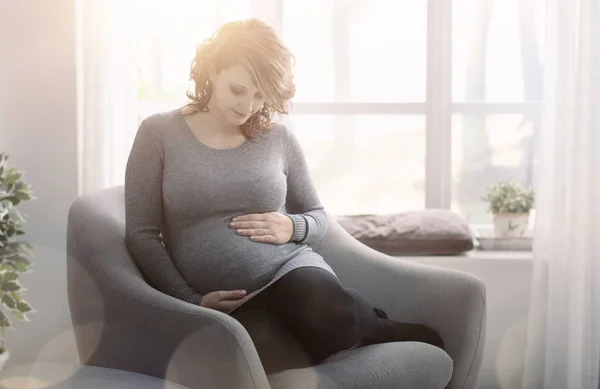 Jovem grávida relaxante em casa — Fotografia de Stock