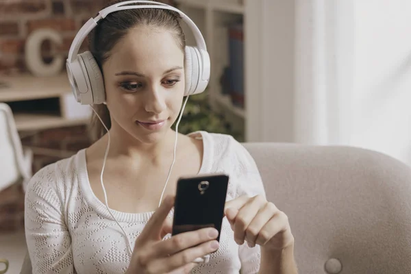 Meisje met haar telefoon aansluiten en luisteren naar muziek — Stockfoto