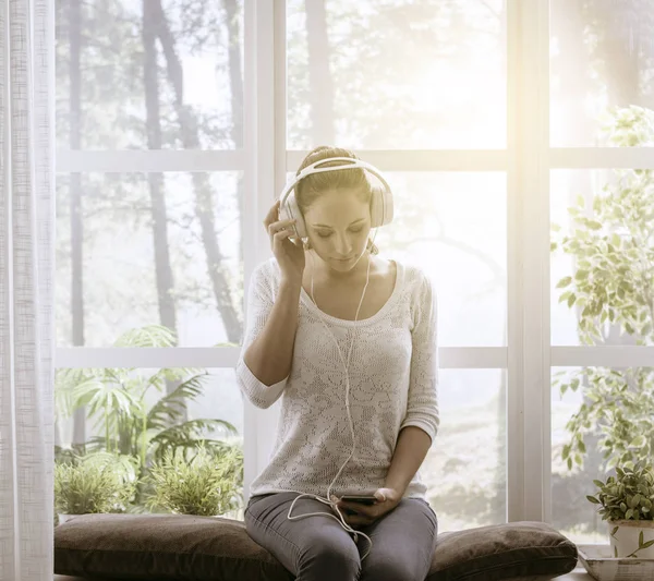 Entspannte Frau hört zu Hause Musik — Stockfoto