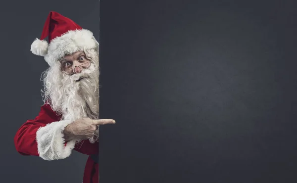 Joyeux Père Noël pointant vers un panneau vierge — Photo