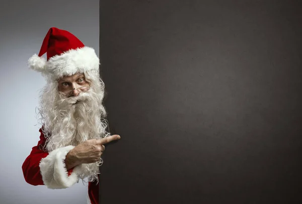 Joyeux Père Noël pointant vers un panneau vierge — Photo
