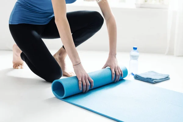 Genç kadın egzersiz sonra onun yoga mat haddeleme — Stok fotoğraf