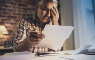 Umutsuz adamın evde aile içi faturalarını kontrol