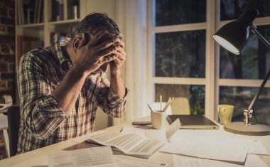 Umutsuz adamın evde aile içi faturalarını kontrol