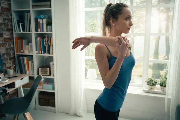 Vrouw doen stretching oefeningen thuis — Stockfoto