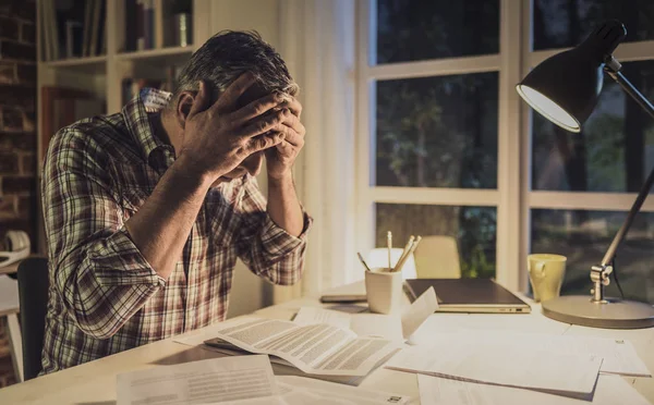 Hombre desesperado revisando sus cuentas domésticas en casa — Foto de Stock