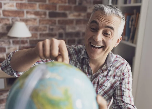 Man houdt een wereldbol en het vinden van locaties — Stockfoto