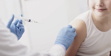 Doktor bir enjeksiyon için genç bir hastaya verilmesi