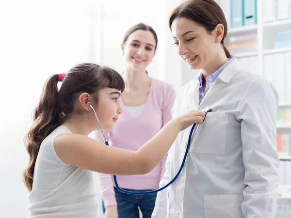 Friendly doctor playing with a young patient during a visit — Stock Photo, Image