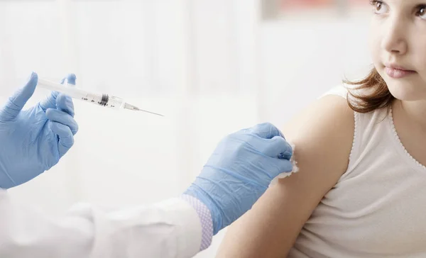 Kvinnliga läkare som ger en injektion till en ung söt tjej — Stockfoto