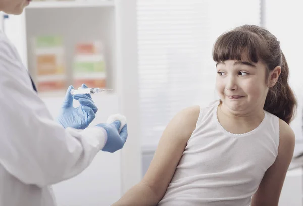 Médico dando una inyección a una joven asustada — Foto de Stock