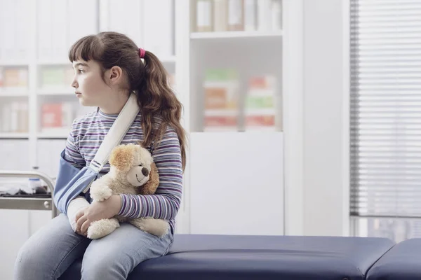 Girl with broken arm waiting in the doctor's office — Stock Photo, Image