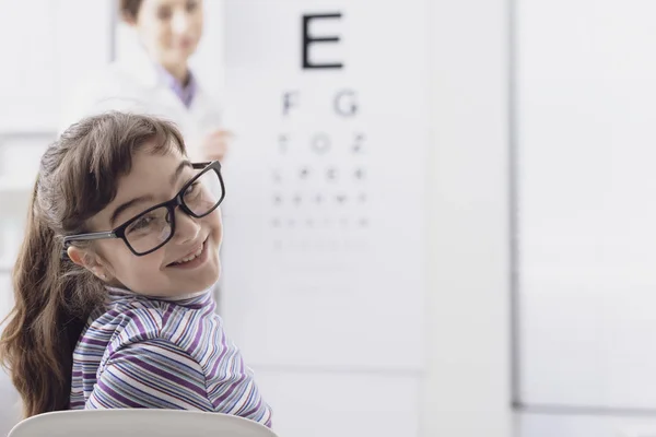 Oculist testing a young patient's eyesight using an eye chart — Stock Photo, Image